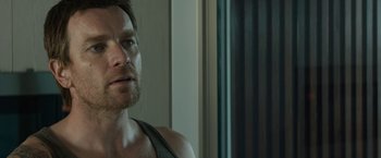 Movie still from “Son of a Gun” (2014), directed by Julius Avery – A person wearing a tank top; Close Up shot, Over the shoulder angle