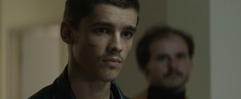 Movie still from “Son of a Gun” (2014), directed by Julius Avery – A person wearing a jacket; Close Up shot, Over the shoulder angle