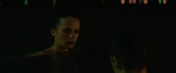 Movie still from “Son of a Gun” (2014), directed by Julius Avery – A woman in the water at night with lights in the background; Close Up shot, Over the shoulder angle
