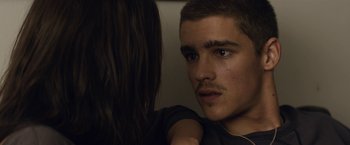 Movie still from “Son of a Gun” (2014), directed by Julius Avery – A man with a mustache and a woman with long brown hair; Close Up shot, Over the shoulder angle