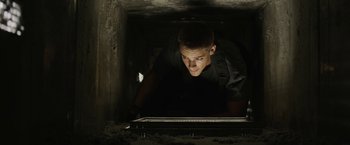 Movie still from “Son of a Gun” (2014), directed by Julius Avery – A man looking at a computer screen in a dark room; Close Up shot, Low angle