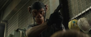 Movie still from “Son of a Gun” (2014), directed by Julius Avery – A man wearing a monkey mask and holding a gun; Close Up shot, Low angle