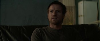 Movie still from “Son of a Gun” (2014), directed by Julius Avery – A person sitting on a couch; Close Up shot, Over the shoulder angle