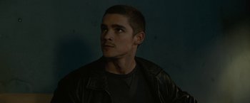 Movie still from “Son of a Gun” (2014), directed by Julius Avery – A man in a black shirt and a black leather jacket; Close Up shot, Low angle