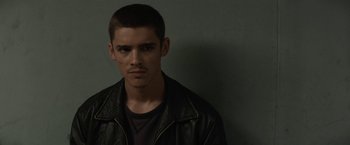 Movie still from “Son of a Gun” (2014), directed by Julius Avery – A man in a leather jacket is looking at the camera; Close Up shot, Over the shoulder angle