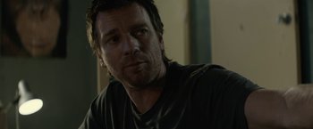 Movie still from “Son of a Gun” (2014), directed by Julius Avery – A person wearing a black t - shirt; Close Up shot, Over the shoulder angle