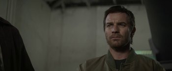 Movie still from “Son of a Gun” (2014), directed by Julius Avery – A person wearing a jacket looking at the camera; Close Up shot, Low angle