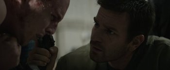 Movie still from “Son of a Gun” (2014), directed by Julius Avery – Two men looking at each other while on a cell phone; Close Up shot, Over the shoulder angle