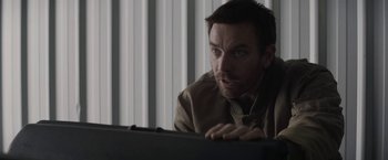 Movie still from “Son of a Gun” (2014), directed by Julius Avery – A man looking at a computer screen while sitting in front of a window; Close Up shot, Over the shoulder angle