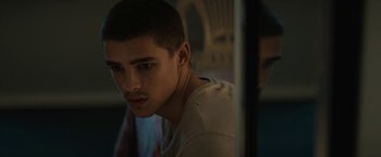Movie still from “Son of a Gun” (2014), directed by Julius Avery – A young man looking at the reflection of himself in a mirror; Close Up shot, Low angle