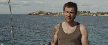 Movie still from “Son of a Gun” (2014), directed by Julius Avery – A man standing in front of a body of water; Close Up shot, Over the shoulder angle