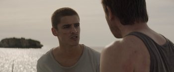 Movie still from “Son of a Gun” (2014), directed by Julius Avery – A man talking to another man on a beach; Close Up shot, Over the shoulder angle