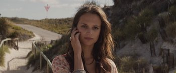 Movie still from “Son of a Gun” (2014), directed by Julius Avery – A beautiful young woman holding a cell phone to her ear; Close Up shot, High angle