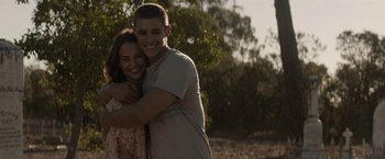 Movie still from “Son of a Gun” (2014), directed by Julius Avery – A man and a woman hugging in a field; Medium shot, Over the shoulder angle