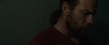 Movie still from “Son of a Gun” (2014), directed by Julius Avery – A person with long hair and a beard; Close Up shot, Low angle