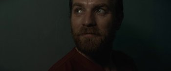 Movie still from “Son of a Gun” (2014), directed by Julius Avery – A person with a beard looking at the camera; Close Up shot, Low angle