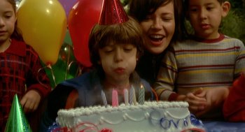 Movie still from “One Hour Photo” (2002), directed by Mark Romanek – A child blowing out candles on a birthday cake; Close Up shot, High angle