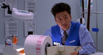 Movie still from “One Hour Photo” (2002), directed by Mark Romanek – A man wearing a blue vest and a tie; Close Up shot, Low angle