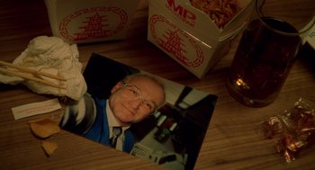 Movie still from “One Hour Photo” (2002), directed by Mark Romanek – A picture of a man sitting in front of a box of noodles; Extreme Close Up shot, Overhead angle