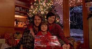 Movie still from “One Hour Photo” (2002), directed by Mark Romanek – A man , woman , and child pose for a picture in front of a christmas tree; Medium shot, Low angle
