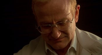 Movie still from “One Hour Photo” (2002), directed by Mark Romanek – A person wearing glasses and a white shirt; Close Up shot, Low angle