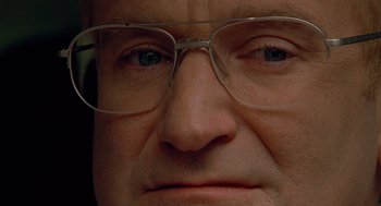 Movie still from “One Hour Photo” (2002), directed by Mark Romanek – An older man wearing glasses looking at the camera; Extreme Close Up shot, Over the shoulder angle