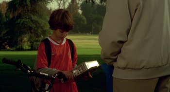 Movie still from “One Hour Photo” (2002), directed by Mark Romanek – A young boy is looking at an electric guitar; Medium shot, High angle