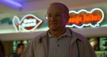 Movie still from “One Hour Photo” (2002), directed by Mark Romanek – An older man wearing glasses standing in front of neon signs; Close Up shot, Low angle