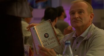 Movie still from “One Hour Photo” (2002), directed by Mark Romanek – A man holding a book in his hands; Close Up shot, Over the shoulder angle