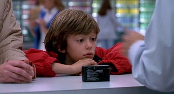 Movie still from “One Hour Photo” (2002), directed by Mark Romanek – A young boy is looking at a video camera; Close Up shot, Over the shoulder angle