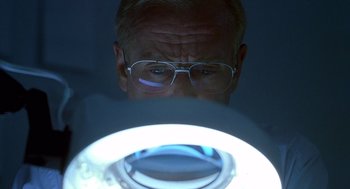 Movie still from “One Hour Photo” (2002), directed by Mark Romanek – An older man wearing glasses looking into a mirror; Extreme Close Up shot, Low angle