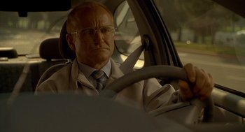 Movie still from “One Hour Photo” (2002), directed by Mark Romanek – An older man driving a car in the street; Close Up shot, Low angle