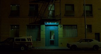 Movie still from “One Hour Photo” (2002), directed by Mark Romanek – A building with a fire escape on the side of the building; Extreme Wide shot, Low angle