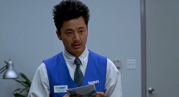 Movie still from “One Hour Photo” (2002), directed by Mark Romanek – A man wearing a blue vest and a blue tie; Close Up shot, Over the shoulder angle