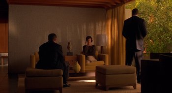 Movie still from “One Hour Photo” (2002), directed by Mark Romanek – Two people are sitting in a living room talking; Wide shot, Over the shoulder angle