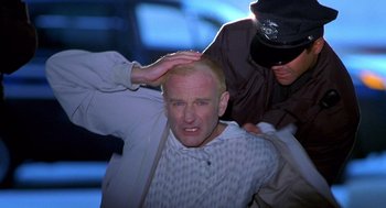 Movie still from “One Hour Photo” (2002), directed by Mark Romanek – A man is being held down by two other men; Close Up shot, Low angle