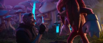 Movie still from “Sonic the Hedgehog 2” (2022), directed by Jeff Fowler – A man sitting in front of an animal with a knife in his mouth; Medium shot, Over the shoulder angle