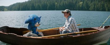 Movie still from “Sonic the Hedgehog 2” (2022), directed by Jeff Fowler – A man sitting in a boat next to sonic the hedgehog; Wide shot, Over the shoulder angle