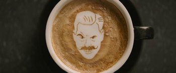 Movie still from “Sonic the Hedgehog 2” (2022), directed by Jeff Fowler – A cup of coffee that has a picture of a man's face on it; Extreme Close Up shot, High angle
