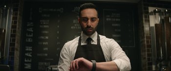 Movie still from “Sonic the Hedgehog 2” (2022), directed by Jeff Fowler – A man wearing an apron looking at his watch; Close Up shot, Low angle