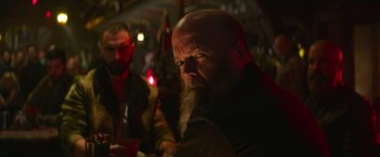 Movie still from “Sonic the Hedgehog 2” (2022), directed by Jeff Fowler – A man with a long beard is sitting at a table with other men; Close Up shot, Low angle