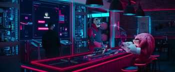 Movie still from “Sonic the Hedgehog 2” (2022), directed by Jeff Fowler – A man is standing at a bar in the dark; Wide shot, Over the shoulder angle