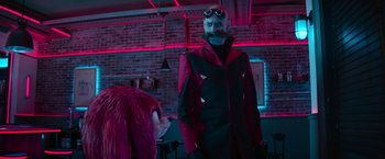 Movie still from “Sonic the Hedgehog 2” (2022), directed by Jeff Fowler – A man in a red and black jacket and a pink wig; Medium shot, Over the shoulder angle