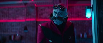 Movie still from “Sonic the Hedgehog 2” (2022), directed by Jeff Fowler – A man with a beard and mustache wearing goggles and a red jacket; Close Up shot, Over the shoulder angle