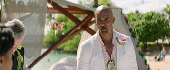 Movie still from “Sonic the Hedgehog 2” (2022), directed by Jeff Fowler – A man in a white suit with a flower in his lapel; Close Up shot, Over the shoulder angle