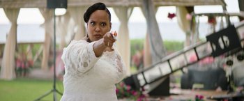 Movie still from “Sonic the Hedgehog 2” (2022), directed by Jeff Fowler – A woman in a white dress is holding a gun; Medium shot, Over the shoulder angle