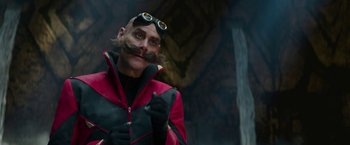 Movie still from “Sonic the Hedgehog 2” (2022), directed by Jeff Fowler – A man with a mustache wearing a red and black jacket; Close Up shot, Low angle