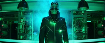 Movie still from “Sonic the Hedgehog 2” (2022), directed by Jeff Fowler – A man in a black jacket and green goggles; Medium shot, Low angle