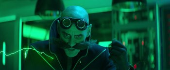 Movie still from “Sonic the Hedgehog 2” (2022), directed by Jeff Fowler – A man with a beard and a mustache wearing goggles and a jacket; Close Up shot, Over the shoulder angle