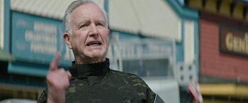 Movie still from “Sonic the Hedgehog 2” (2022), directed by Jeff Fowler – An older man wearing a camouflage jacket; Close Up shot, Over the shoulder angle